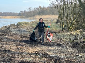 Boswachter raapt afval op in de Loosdrechtse Plassen