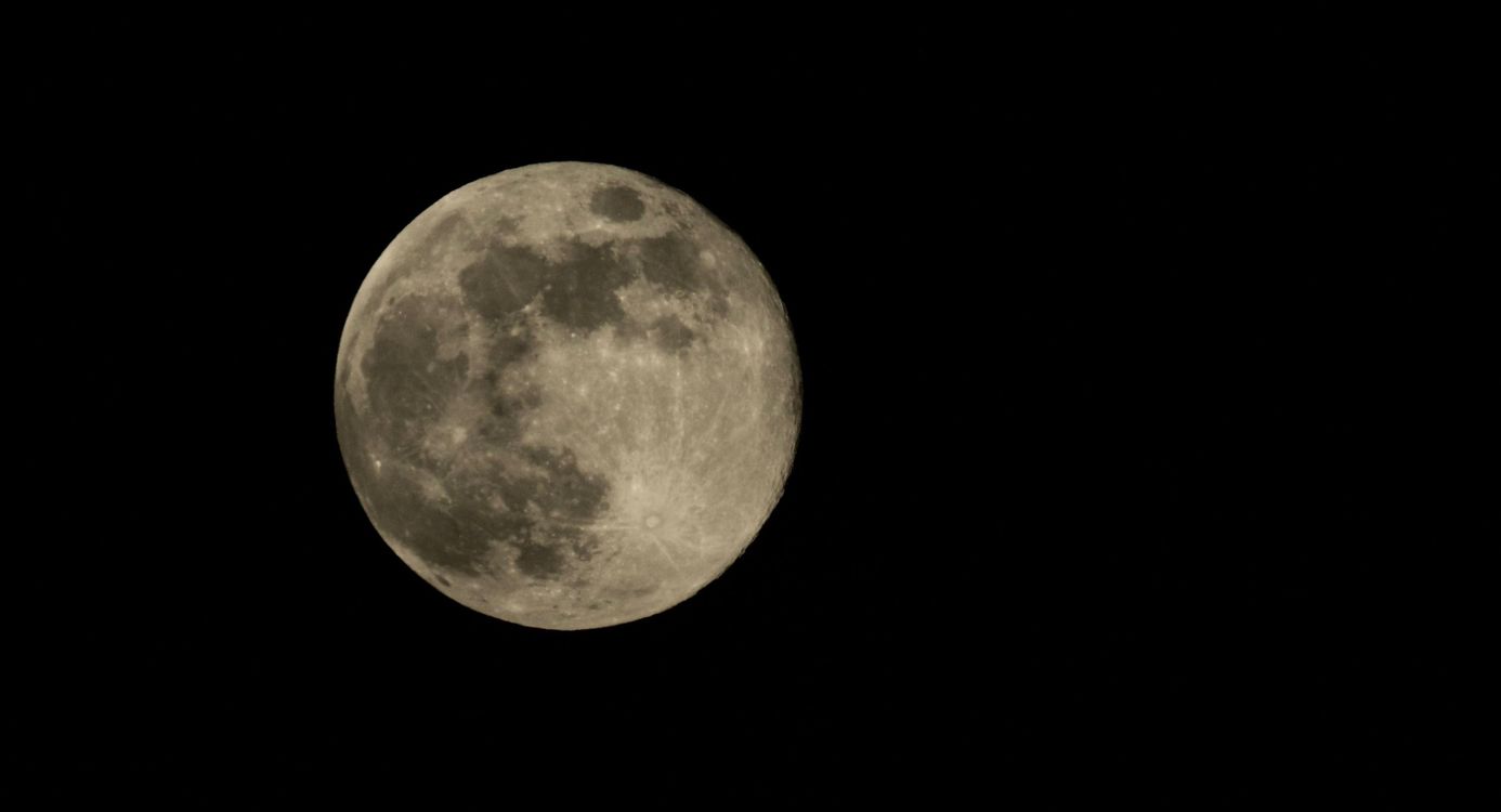 de volle maan aan een donkere hemel