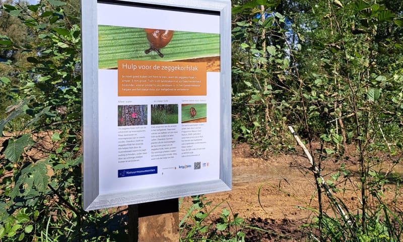 Bordje 'Hulp voor de zeggekorfslak' bij werkzaamheden in het Geleenbeekdal