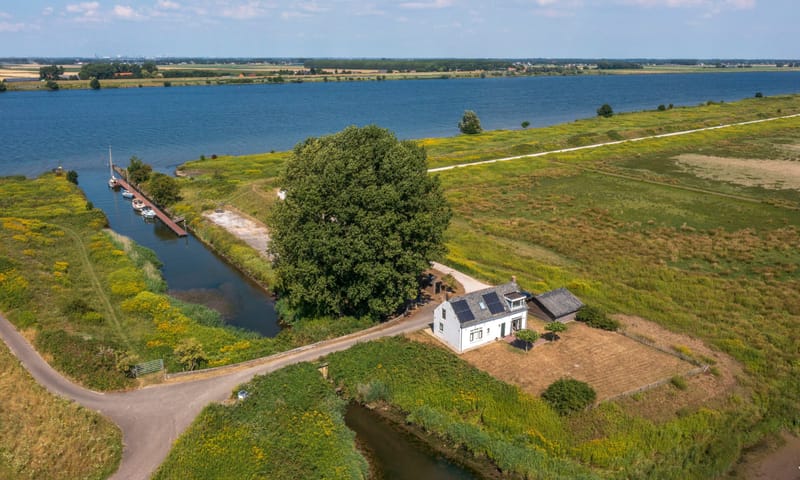 Wit vrijstaand huis bij een haven aan een rivier