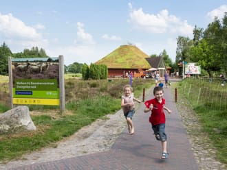 Rennende kinderen bij de entree van het bezoekerscentrum