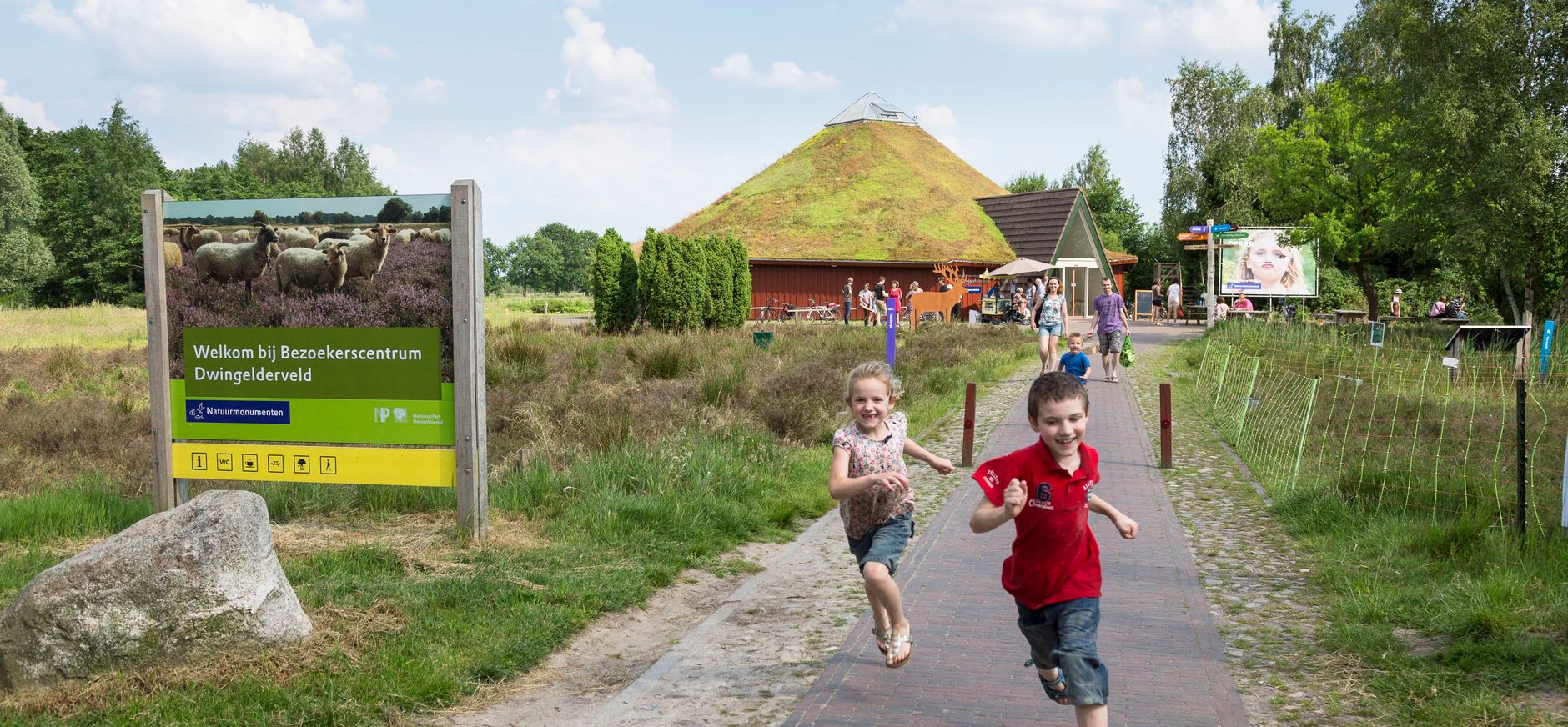 Rennende kinderen bij de entree van het bezoekerscentrum