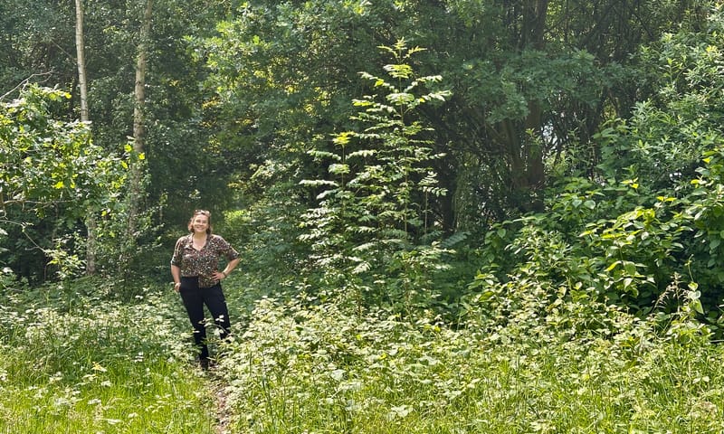 Katja op de plek waar vroeger het Duits Lijntje lag Dame die bij wat struiken en bomen staat