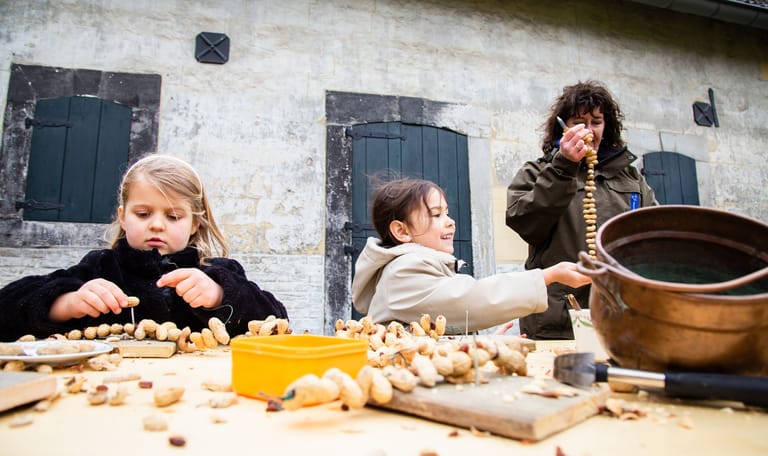 Kinderen maken vogelsnacks van pinda's