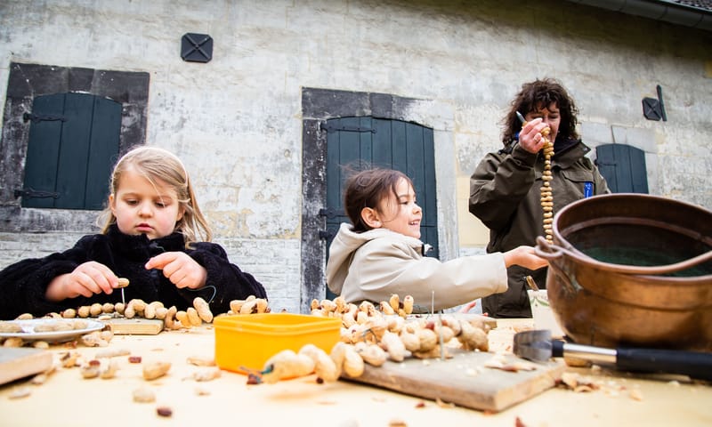 Kinderen maken vogelsnacks van pinda's 