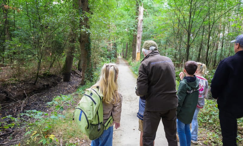 Een kinderfeestje op pad in het bos Dick legt een spelletje uit.