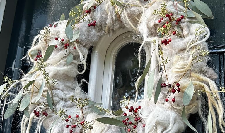 Versierde wolkrans aan deur 