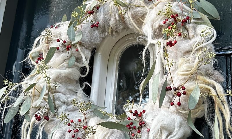 Versierde wolkrans aan deur 