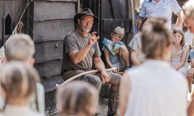 Natuurgids vertelt iets aan groep