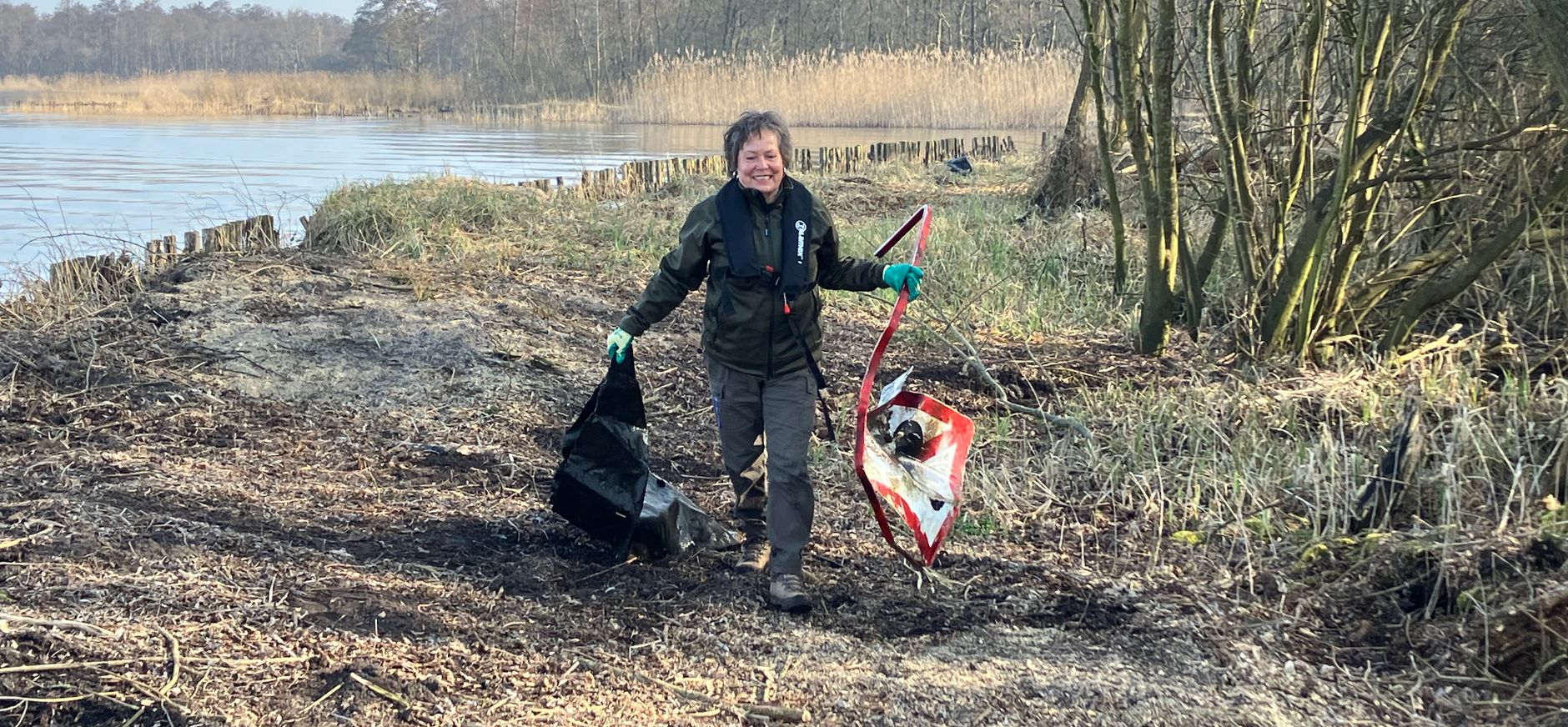 Vrijwillig boswachter Margreet raapt afval op uit de oevers van de Loosdrechtse Plassen