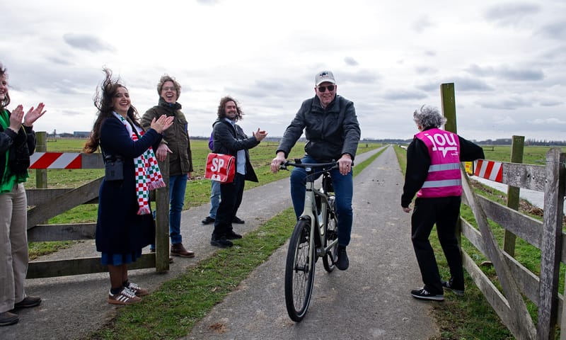 De laatste fietser passeert het te sluiten hek