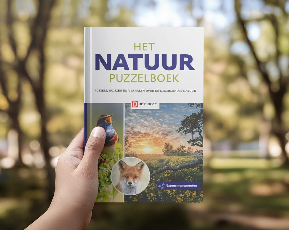 Hand die Het Natuur Puzzelboek vasthoudt