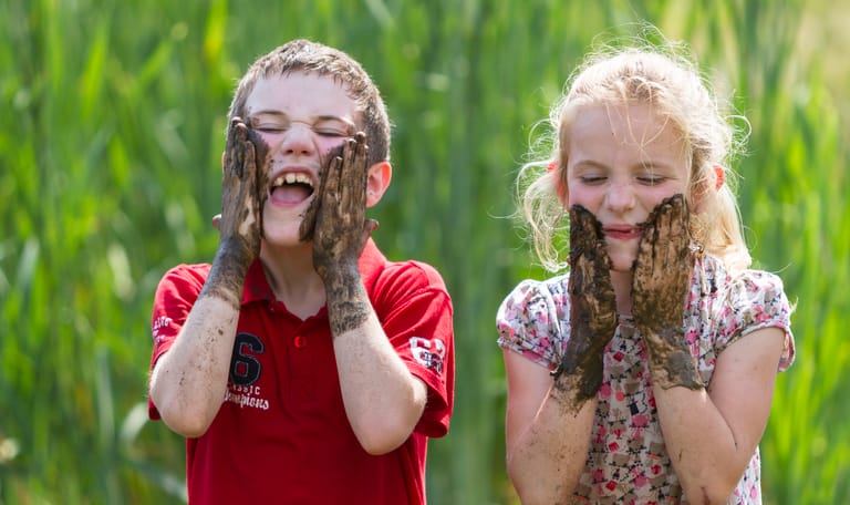 Kinderen maken hun gezicht vies met modder
