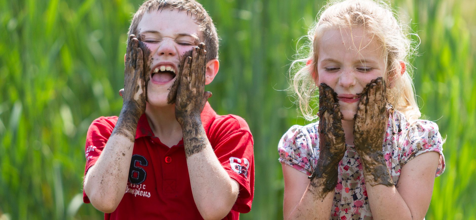 Kinderen maken hun gezicht vies met modder