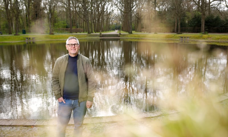 Meneer in beeld die lacht naar de camera