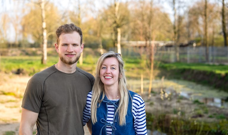Een man en een vrouw die lachend de camera in kijken