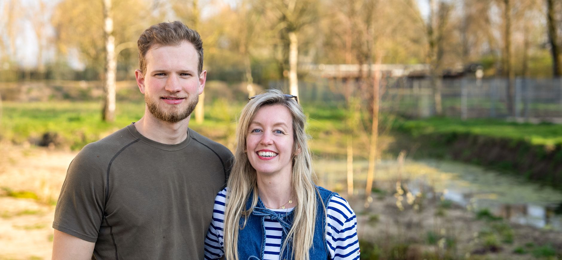 Een man en een vrouw die lachend de camera in kijken