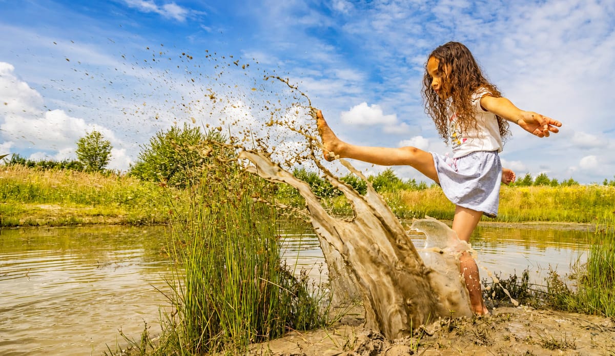 Kinderen spelen bij water op een OERRR-speelplek