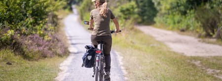 Vrouw fietst op fietspad door het Drentse landschap