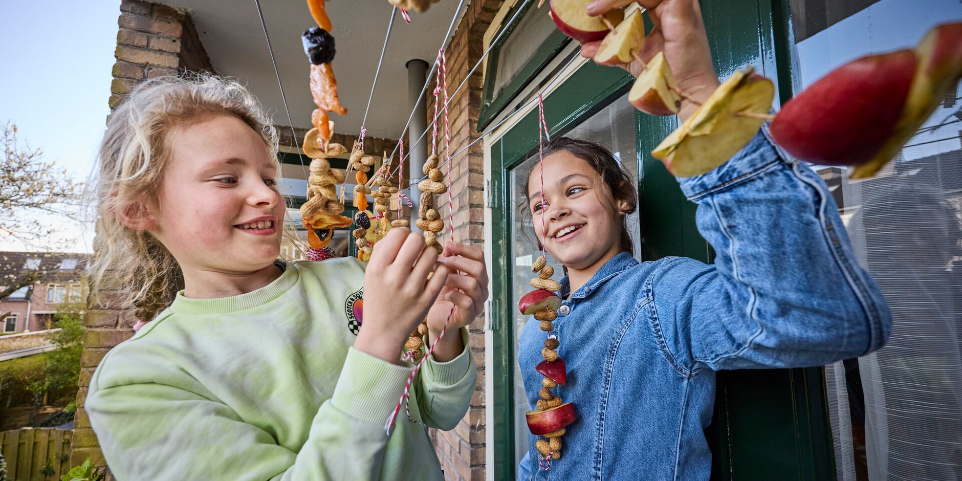 Kinderen maken vogelsnacks op balkon