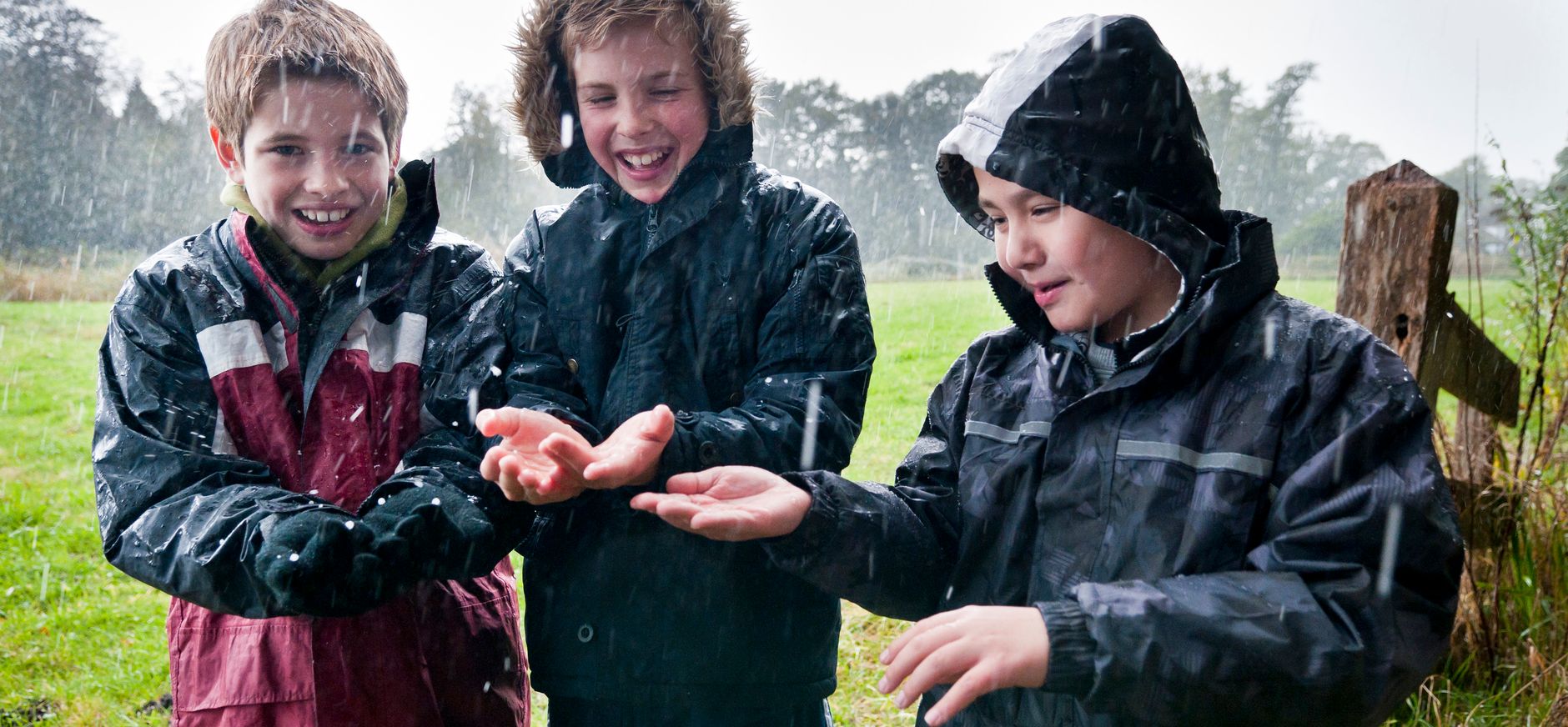Kinderen laten regen op hun handen neerkomen
