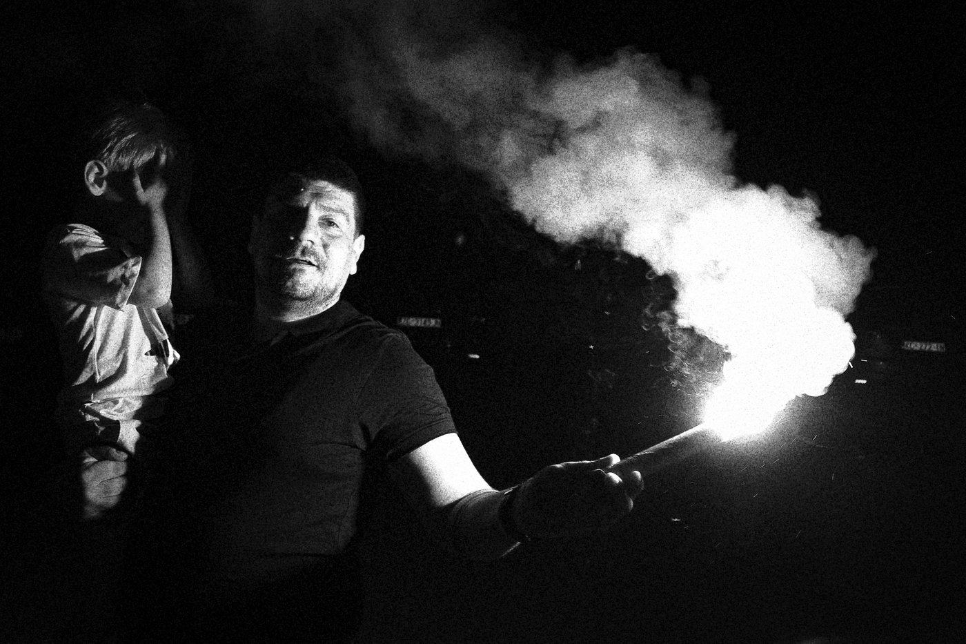 man holding a flare and young boy