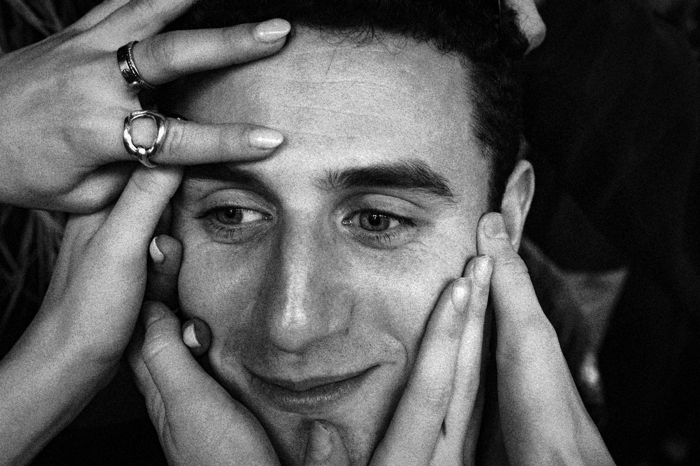 David having his face covered by many hands