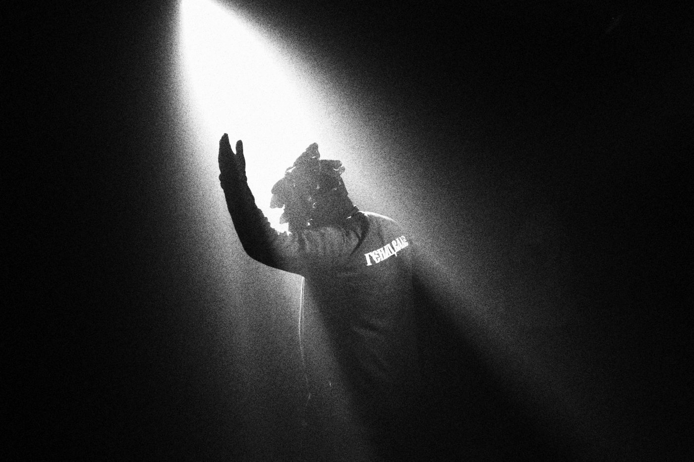 Man with arm extended into a beam of light