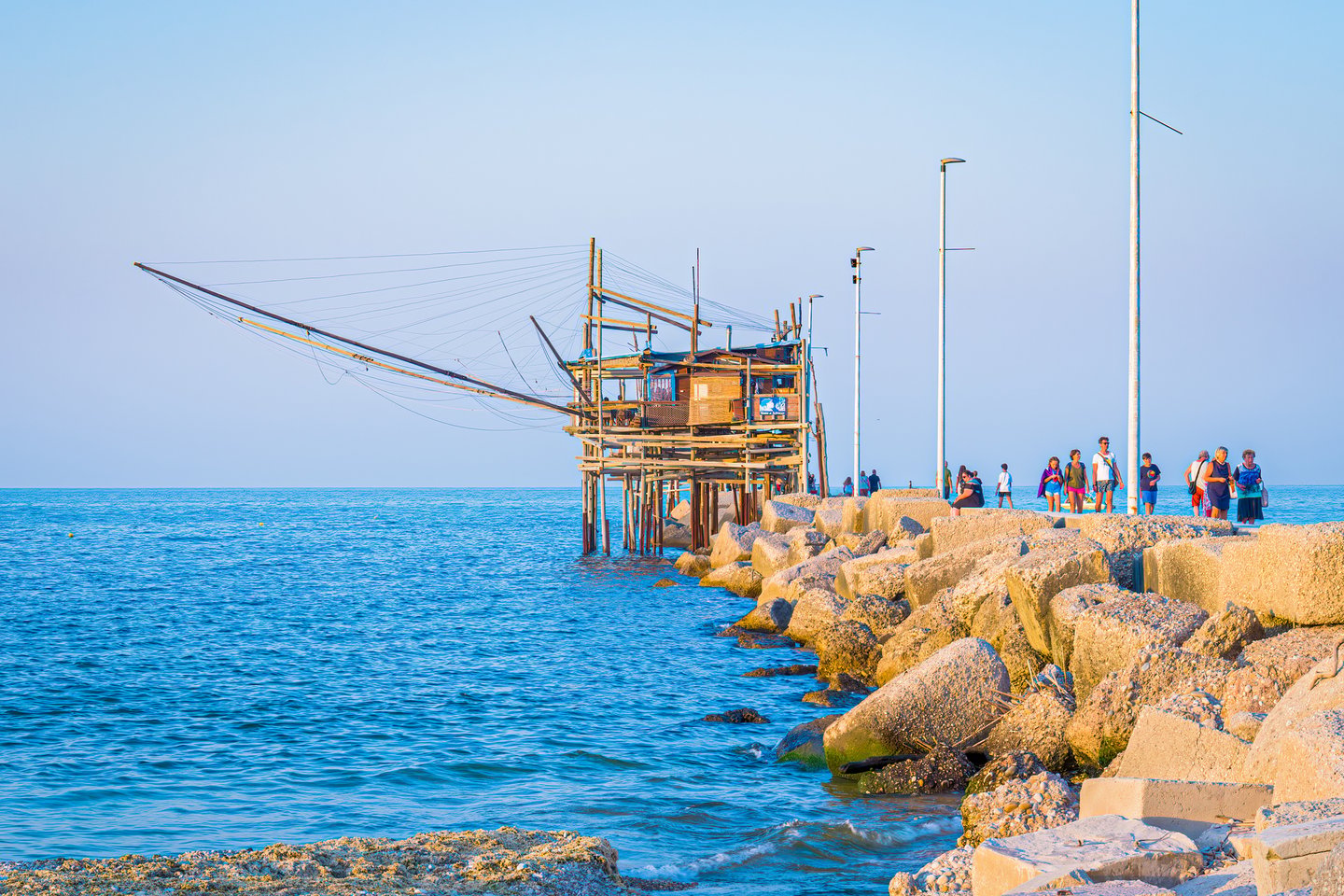 People walking near Trabocco San Giacomo at sunset in Ortona, Abruzzo