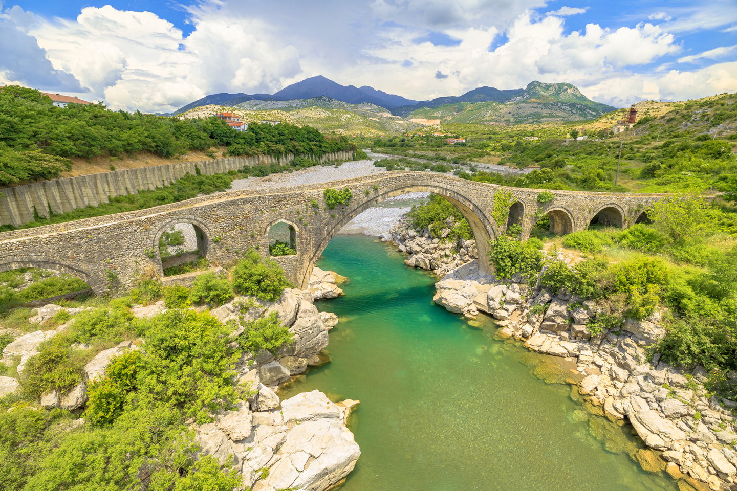 An aerial view of the stone Mesi Bridge and surrounding countryside.