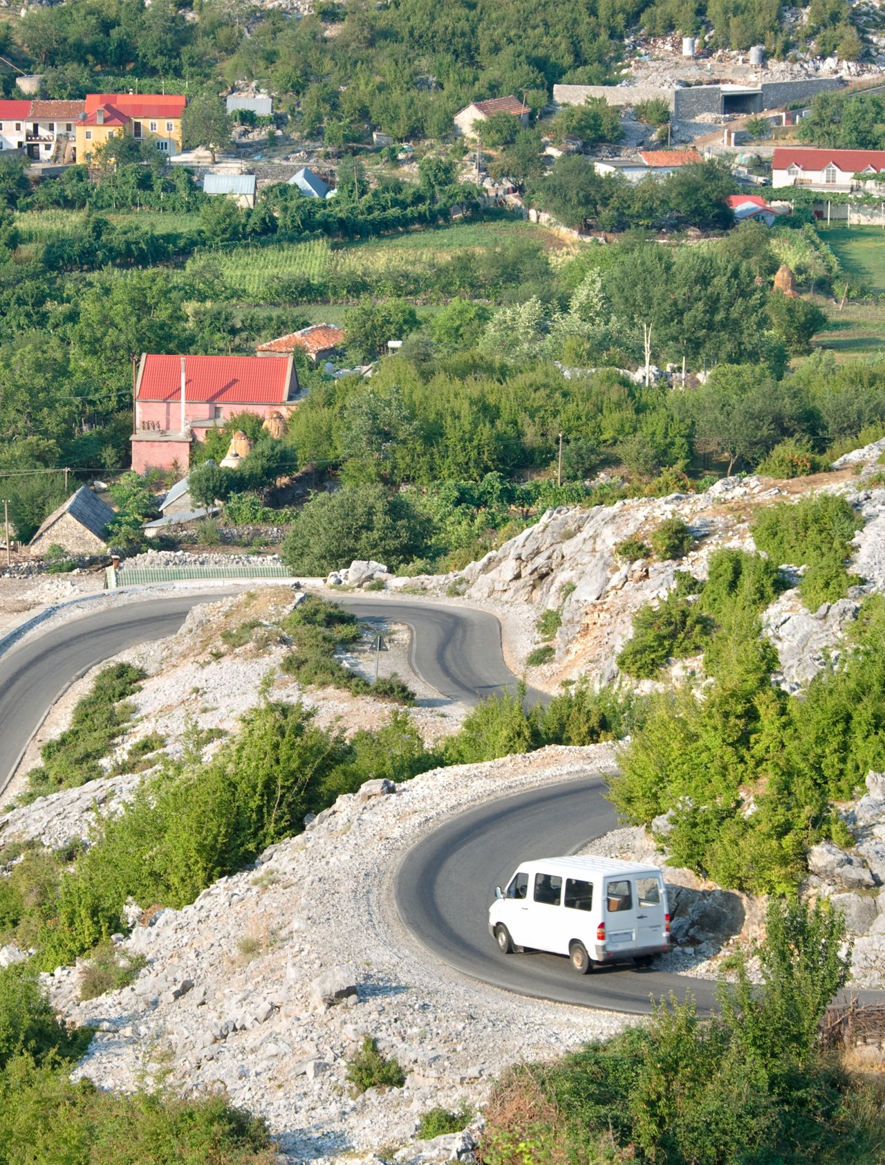 White minibus on the winding road from Razem to Shkoder, Albania