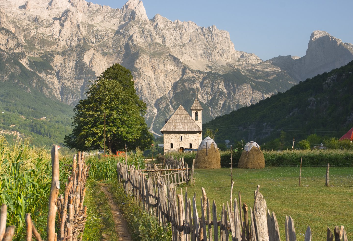 A catholic church in Theth Valley surrounded by mountains