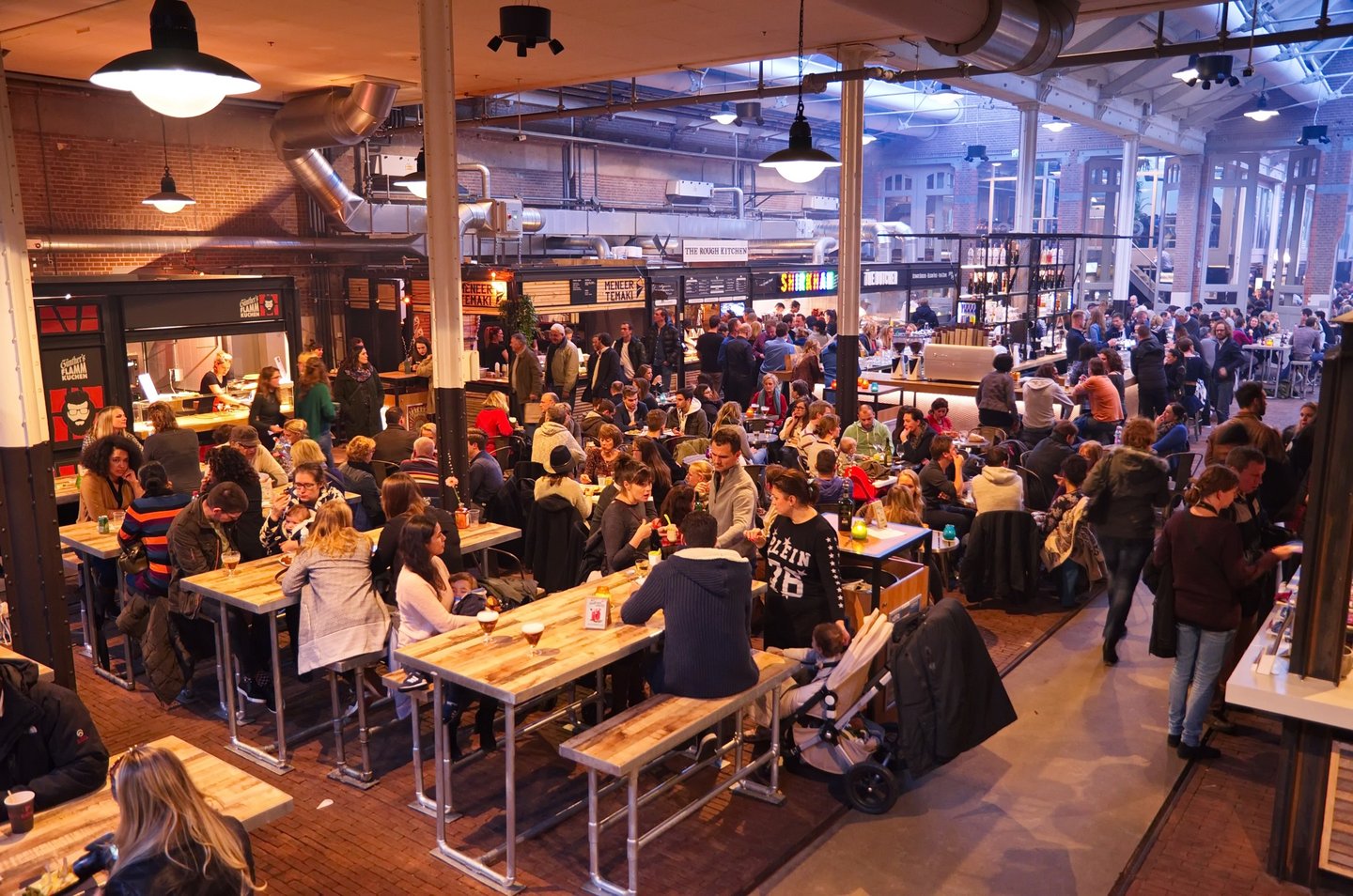 People eating at tables in Foodhallen in Amsterdam