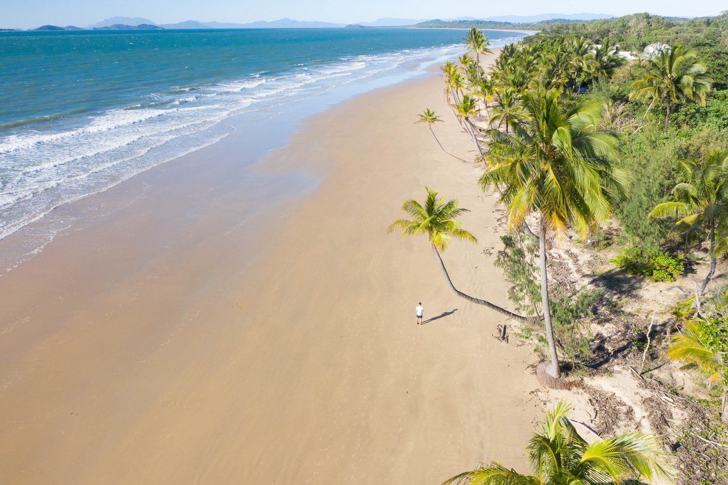 Aerial view of a man standing on Mission Beach in Queensland, Australia.