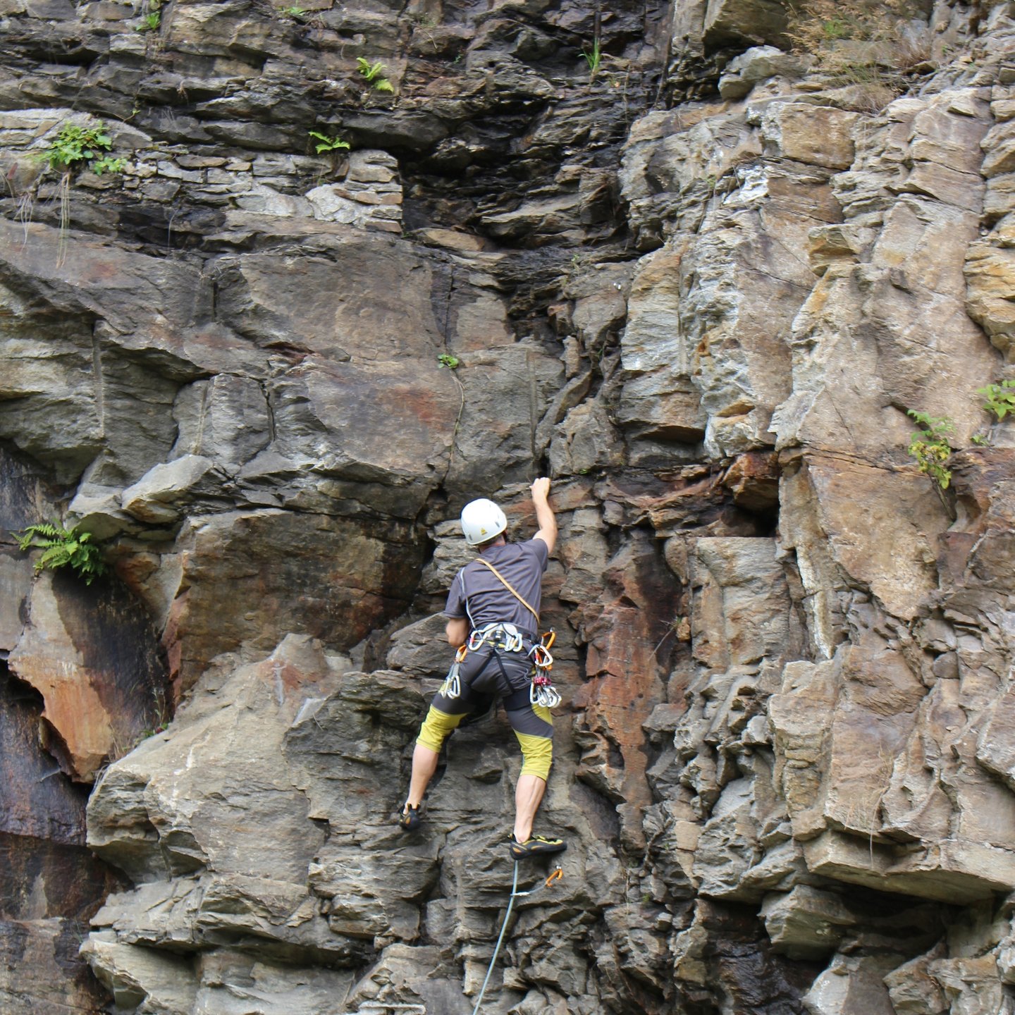 A man climbing a rocky cliff in Bad Gastein, Austria