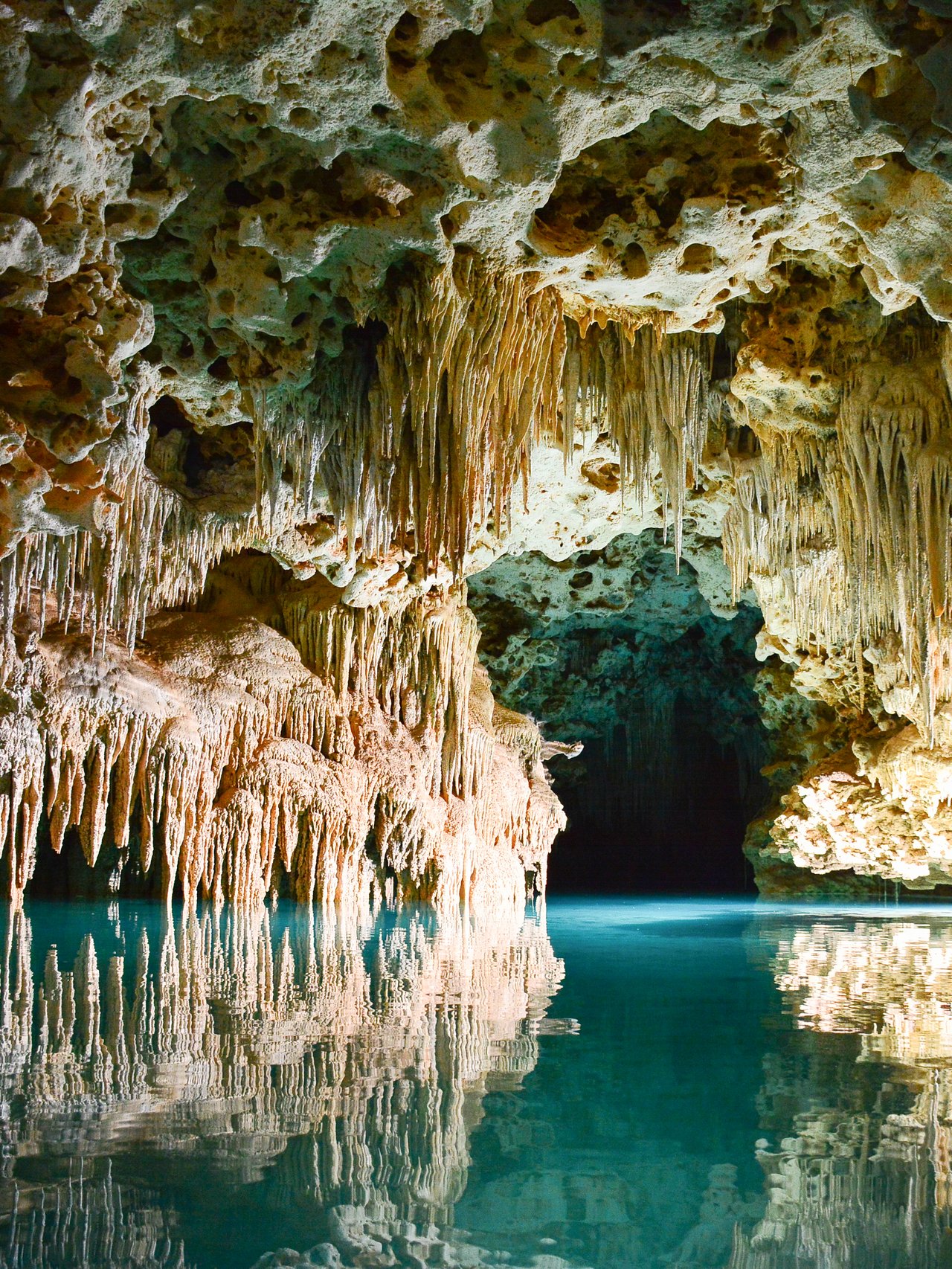 Stalactites hanging over the water in ATM Cave, Belize