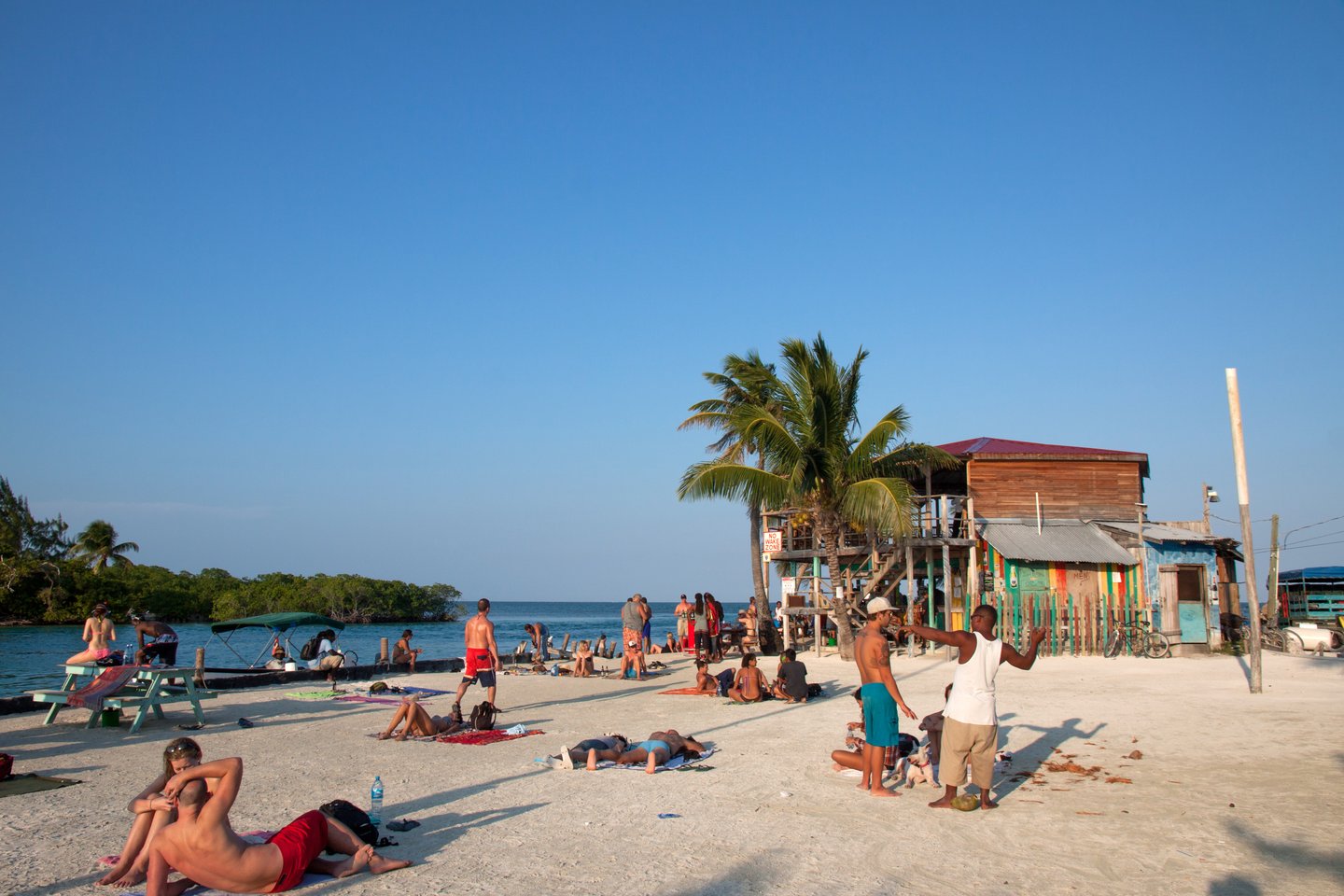 People relaxing on the beach near sunset in Caye Caulker, Belize