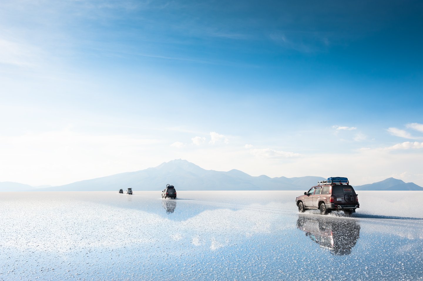 Reflections of jeeps at Salar De Uyuni, Bolivia.