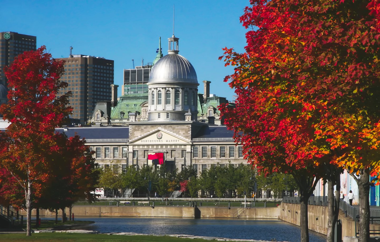 The exterior of Bonsecours Market bordered with colourful trees in the Autumn.