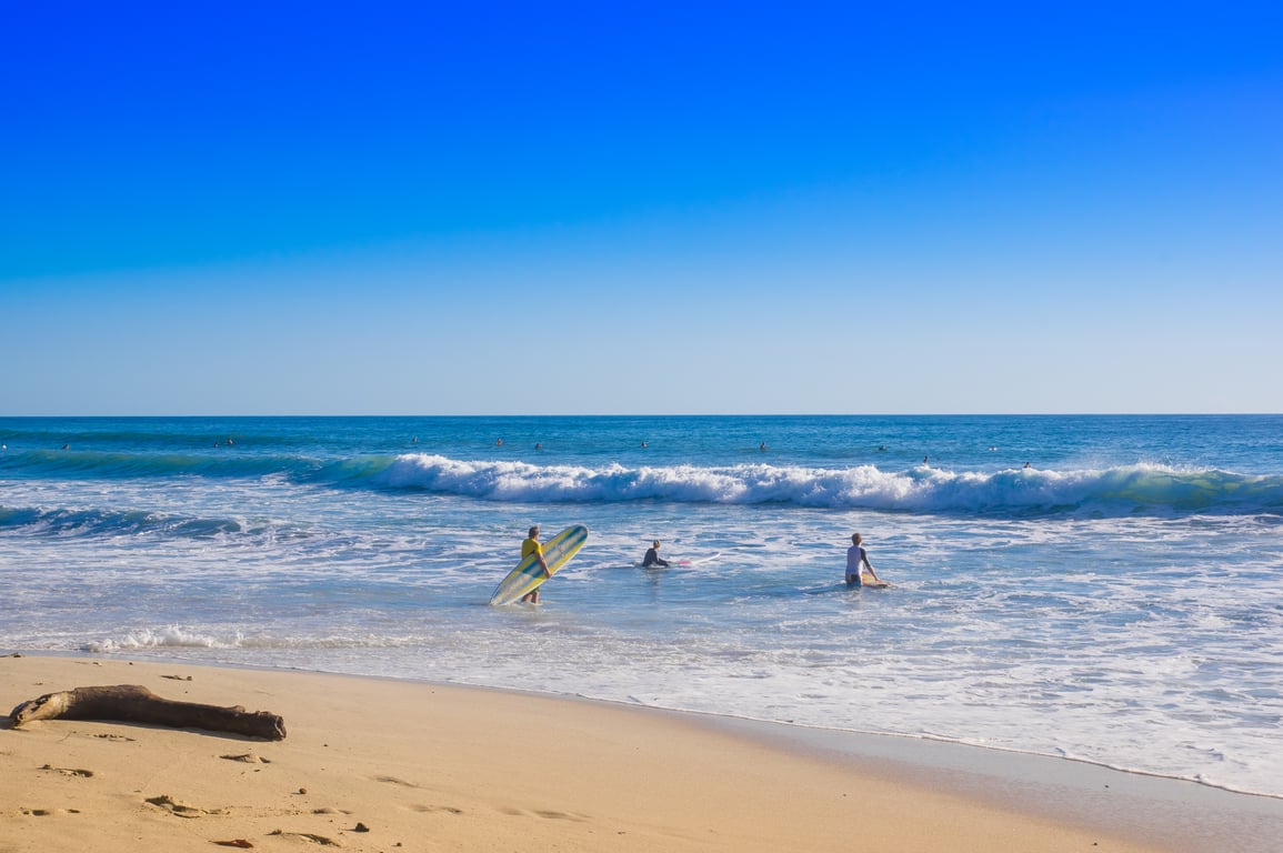 Surfers on Santa Teresa beach in Costa Rica on a beautiful sunny day 