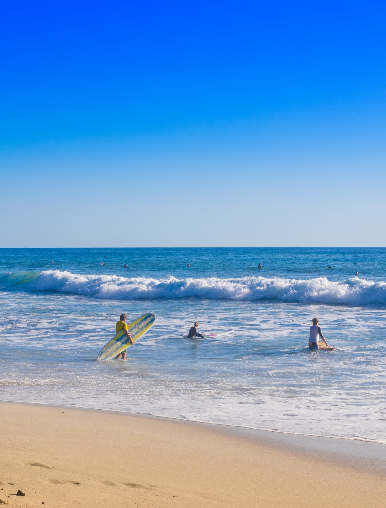 Surfers on Santa Teresa beach in Costa Rica on a beautiful sunny day 