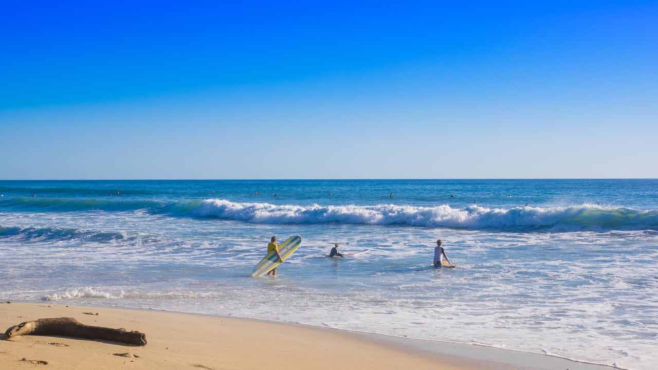 Surfers on Santa Teresa beach in Costa Rica on a beautiful sunny day 