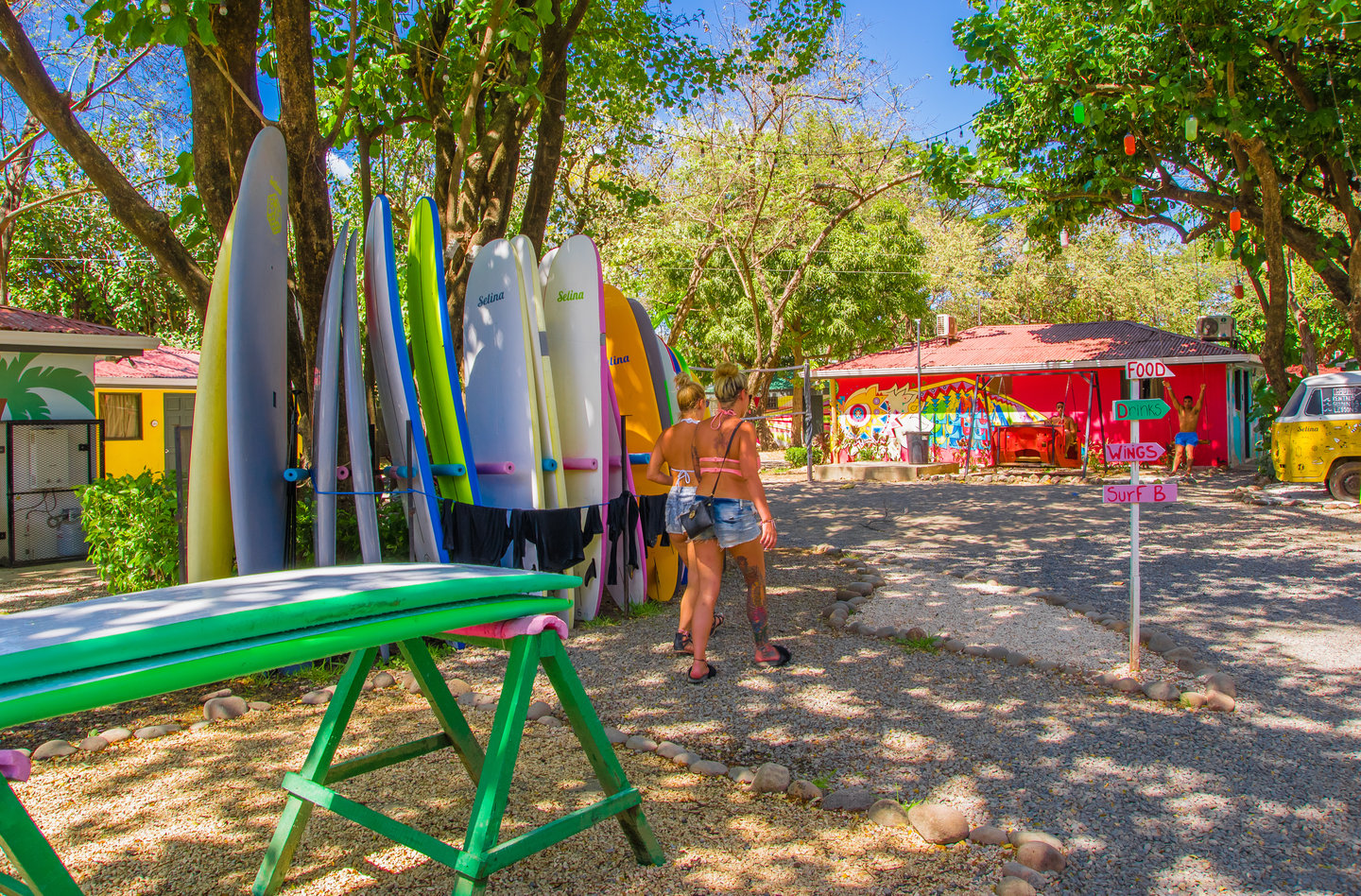 Two woman walking past a surfboard rental shop in Tamarindo, Costa Rica.