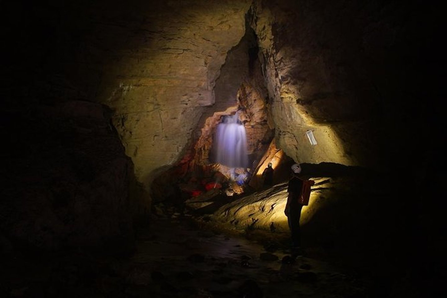A tour group near a waterfall in the Venado Caves