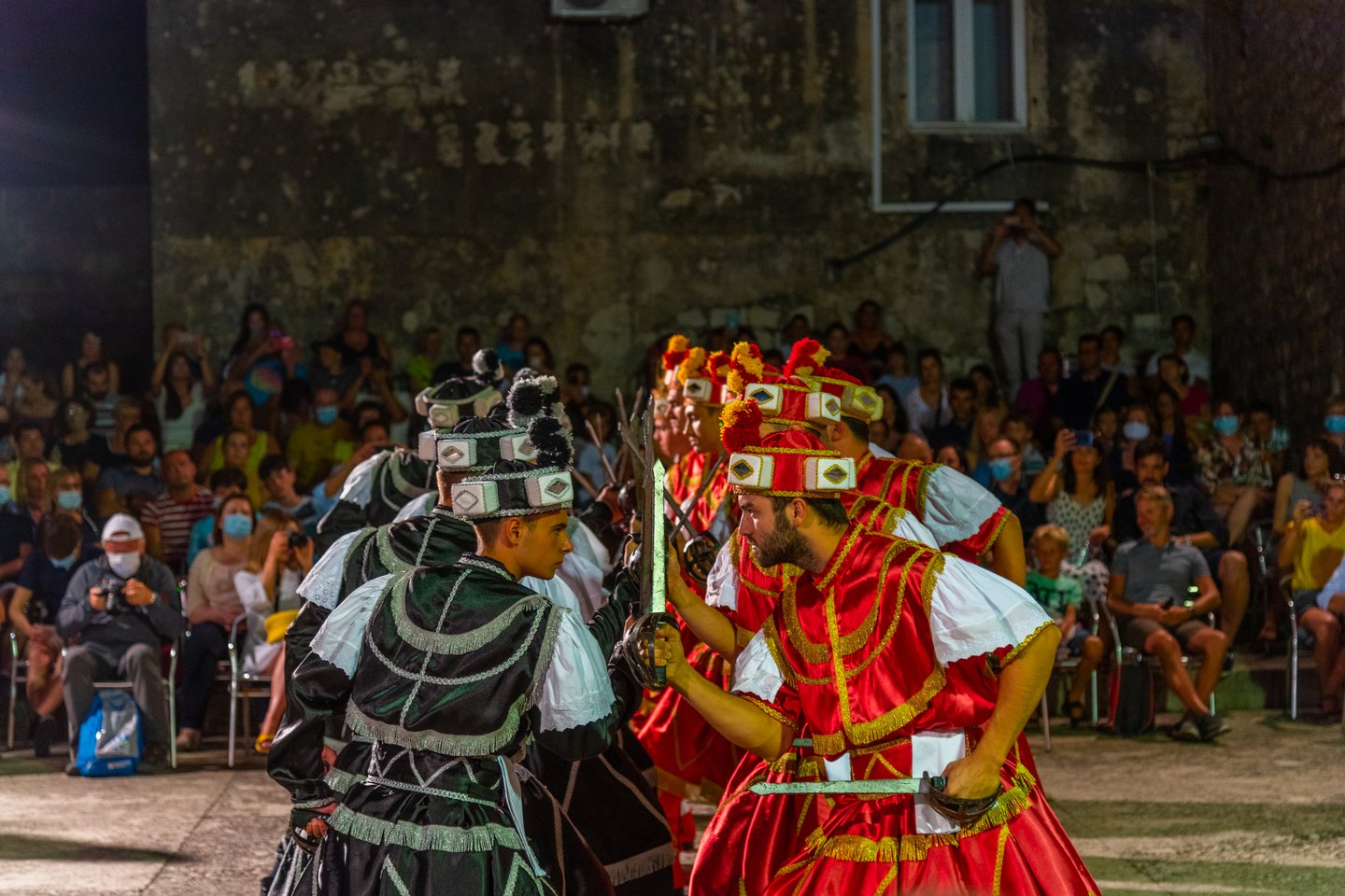 Two lines of men perfomring the Moreska sword dance in Korcula