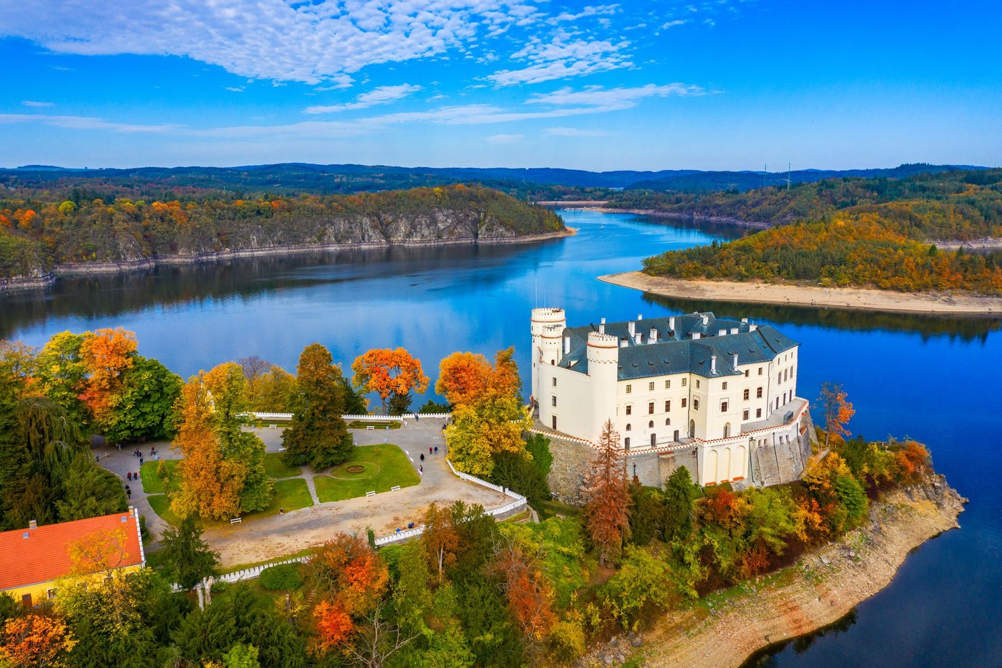 Orlík Castle rising over the reservoir in autumn.