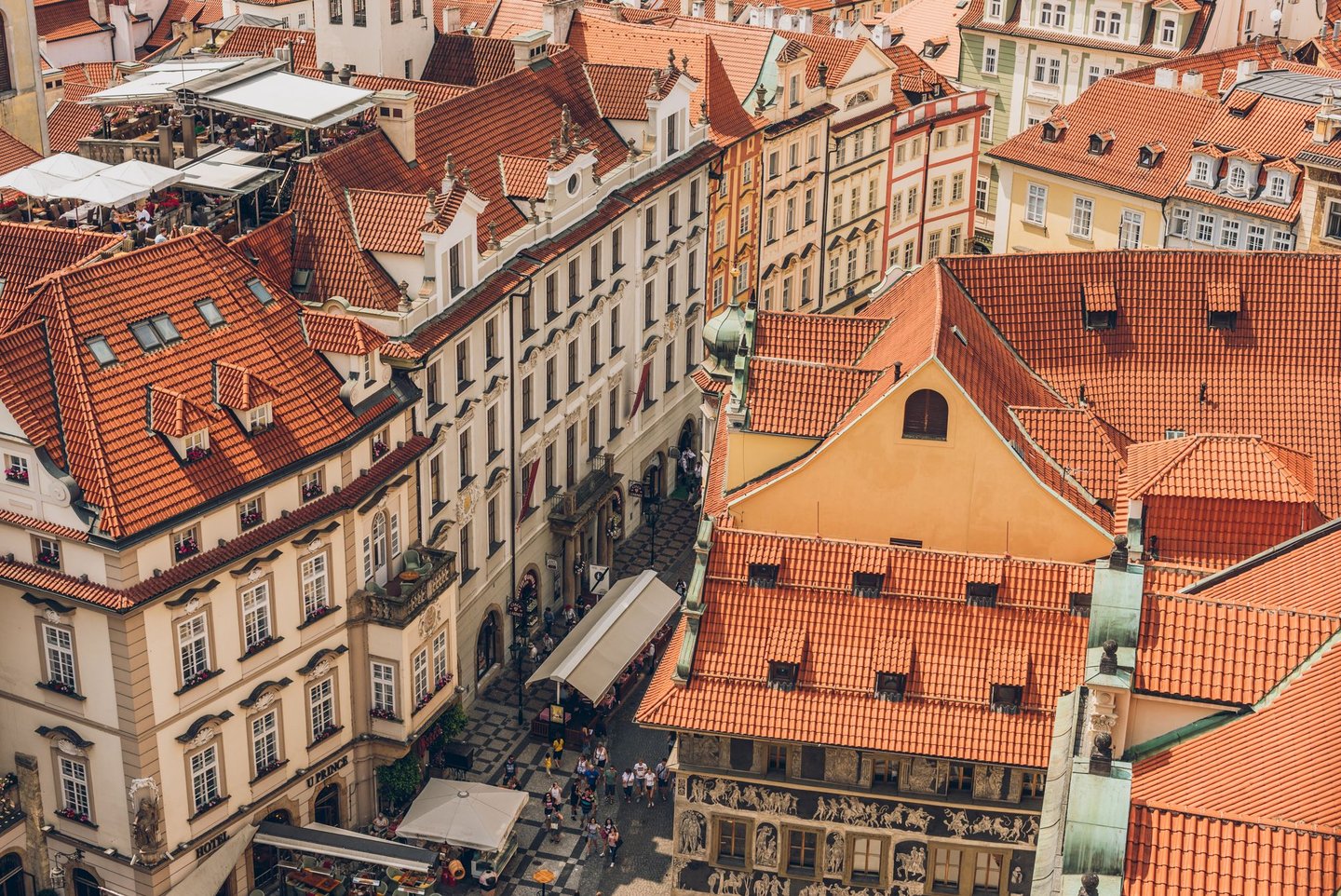 An aerial view of rooftops and people in Prague's Old Town