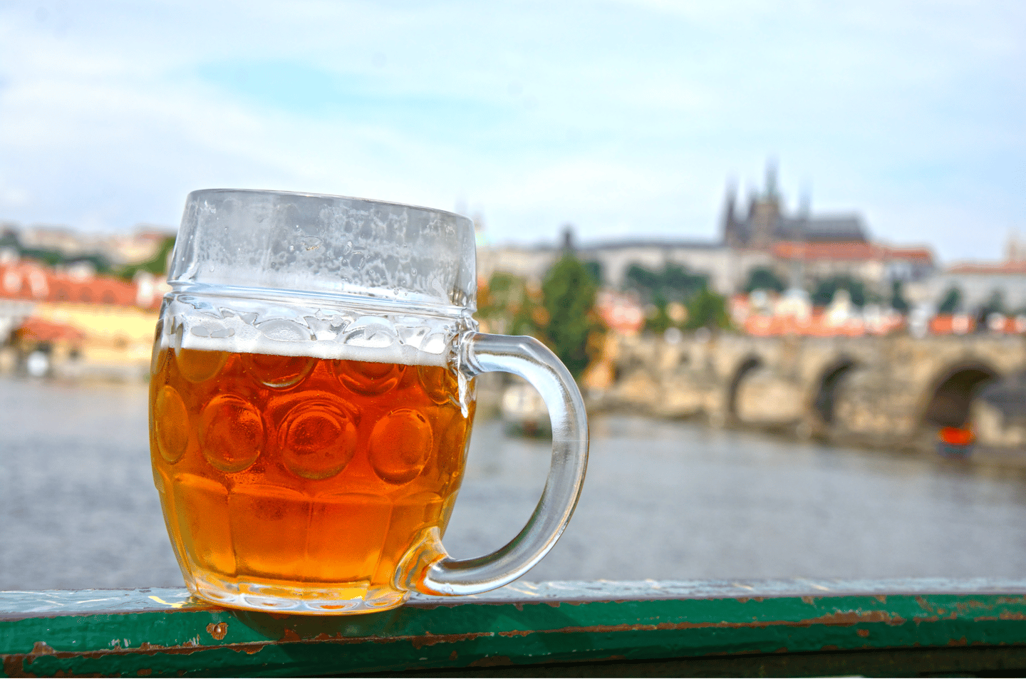 A pint of beer with a view of Prague in the background