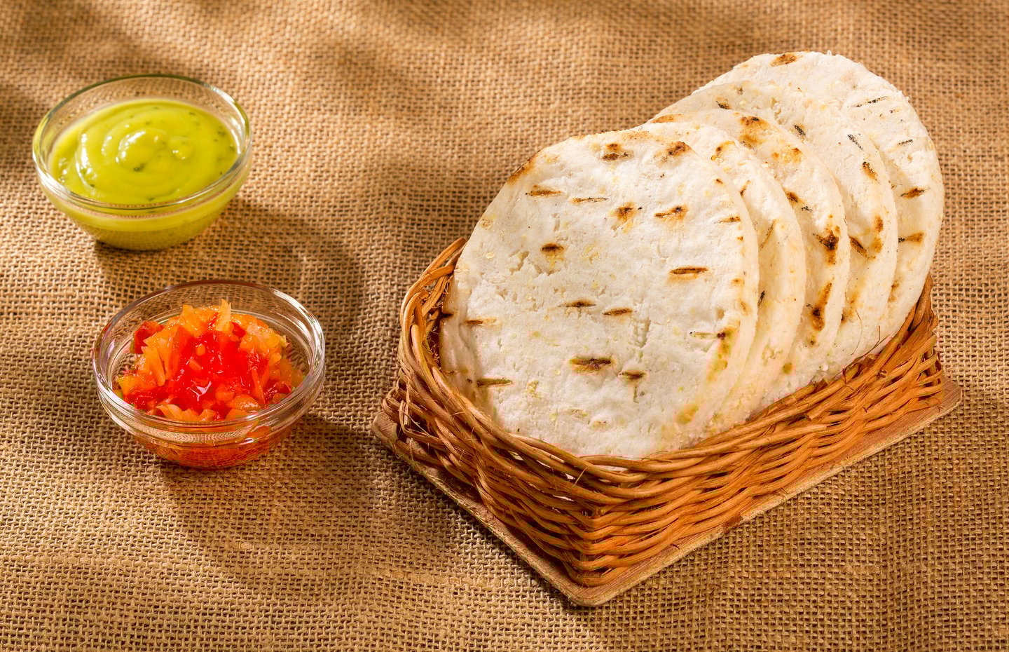 A basket of Colombian corn arepas with hogao