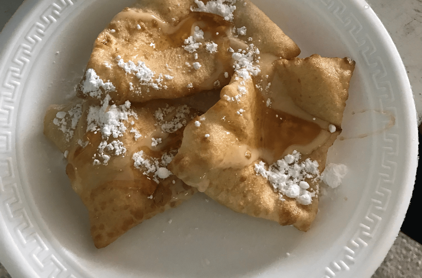 A bowl of fry jacks dusted with icing sugar
